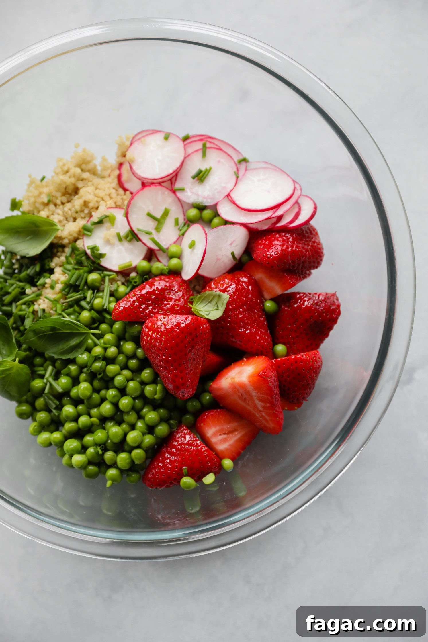 Fresh Strawberry Quinoa Salad with Lime Tahini Dressing 6 quinoa, radishes, strawberries, green peas, basil, and chives in a glass bowl