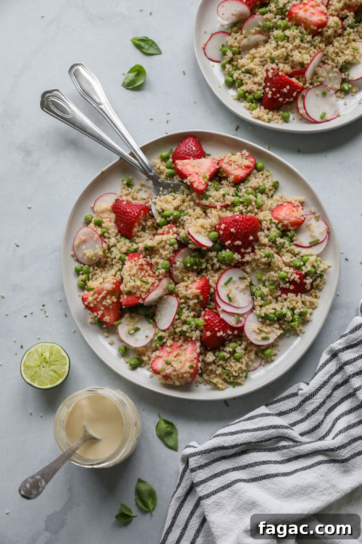 Fresh Strawberry Quinoa Salad with Lime Tahini Dressing 8 Strawberry Quinoa Salad served on plate with forks with blue and white striped towel with zesty lime tahini dressing