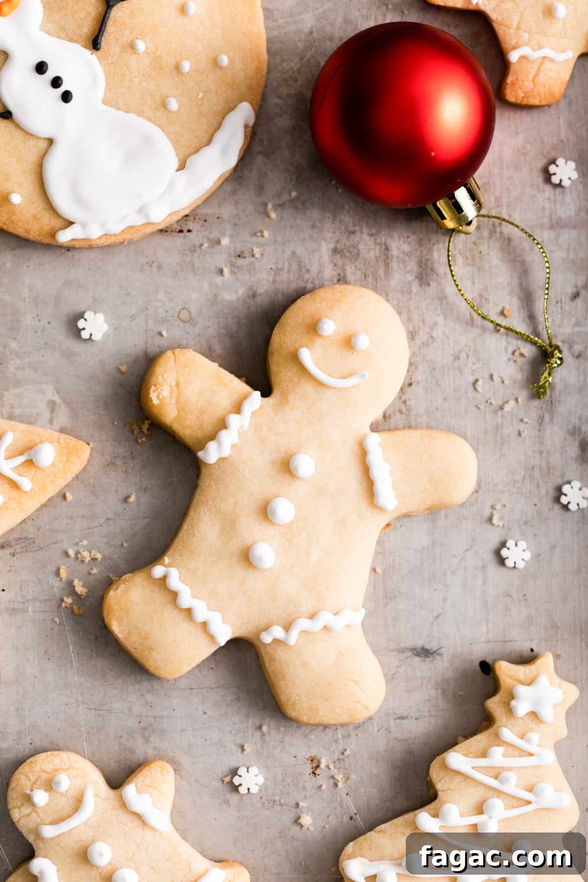 an iced peppermint shortbread cookie in the shape of a gingerbread man surrounded by more iced christmas cookies.