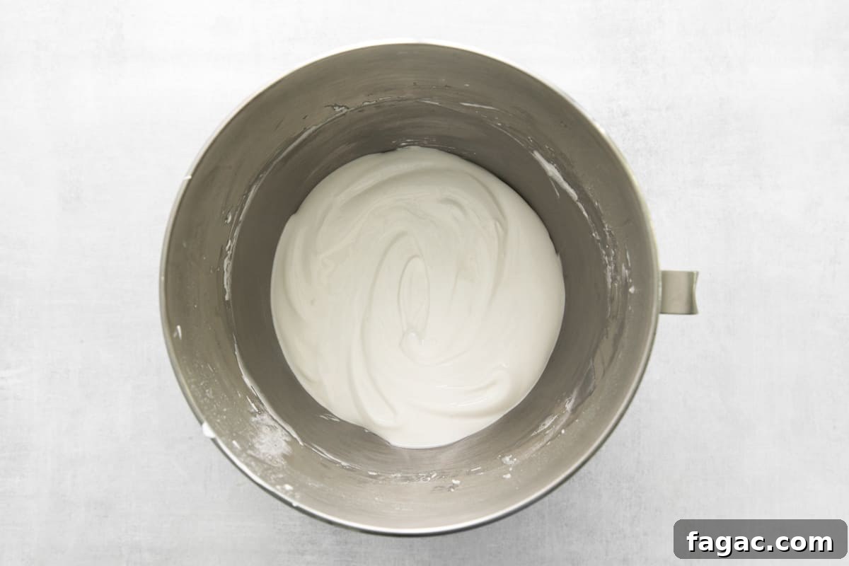 whipped cream in a metal bowl on a white background.