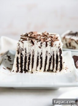 inside of an icebox cake showing vertical layers of chocolate wafers and whipped cream and chocolate shavings on top