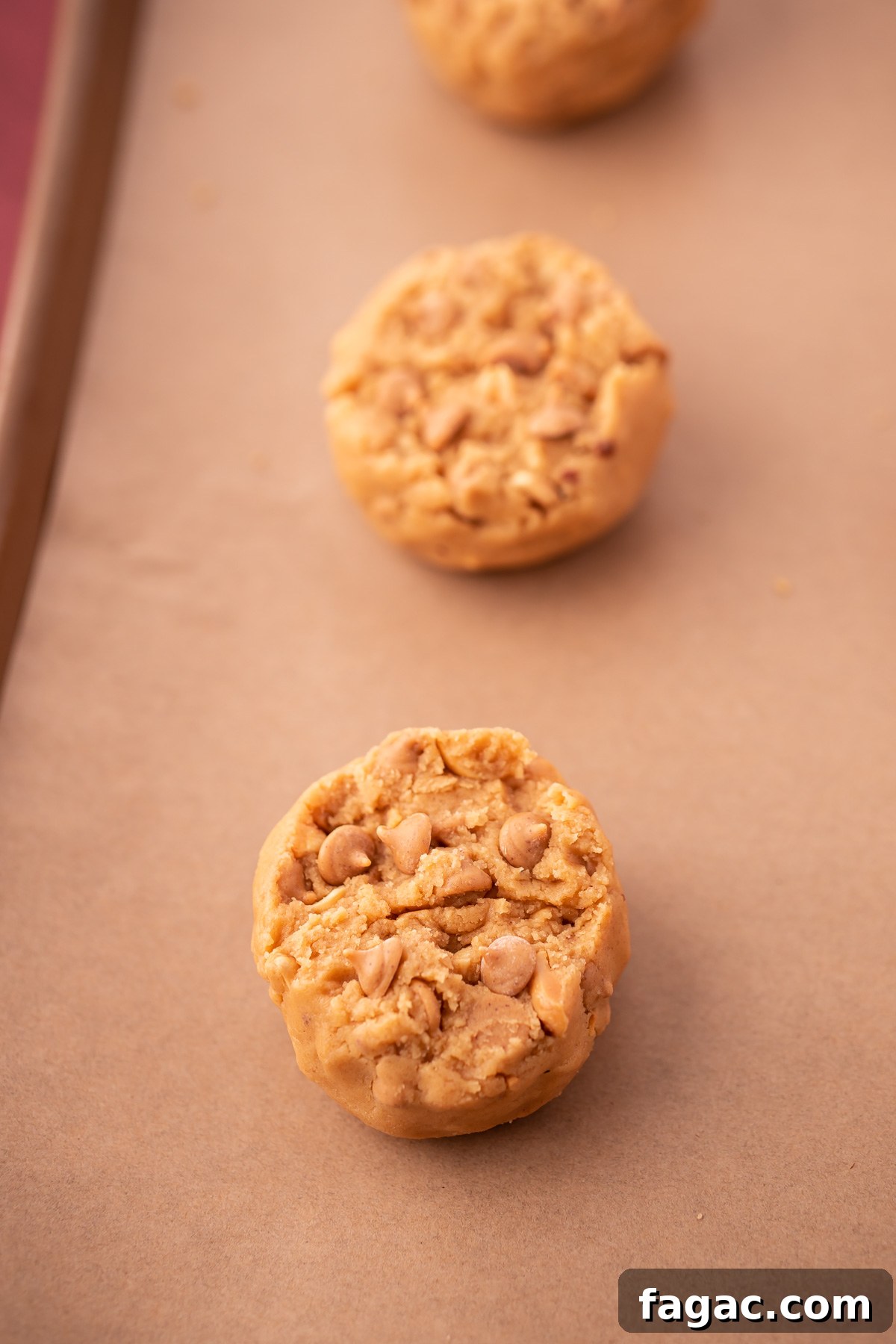Triple Peanut Butter Cookie Dough balls on a baking sheet lined with parchment paper.