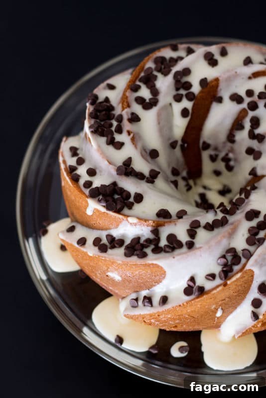 Orange Vanilla Bundt Cake topped with cream cheese frostings and chocolate chips.