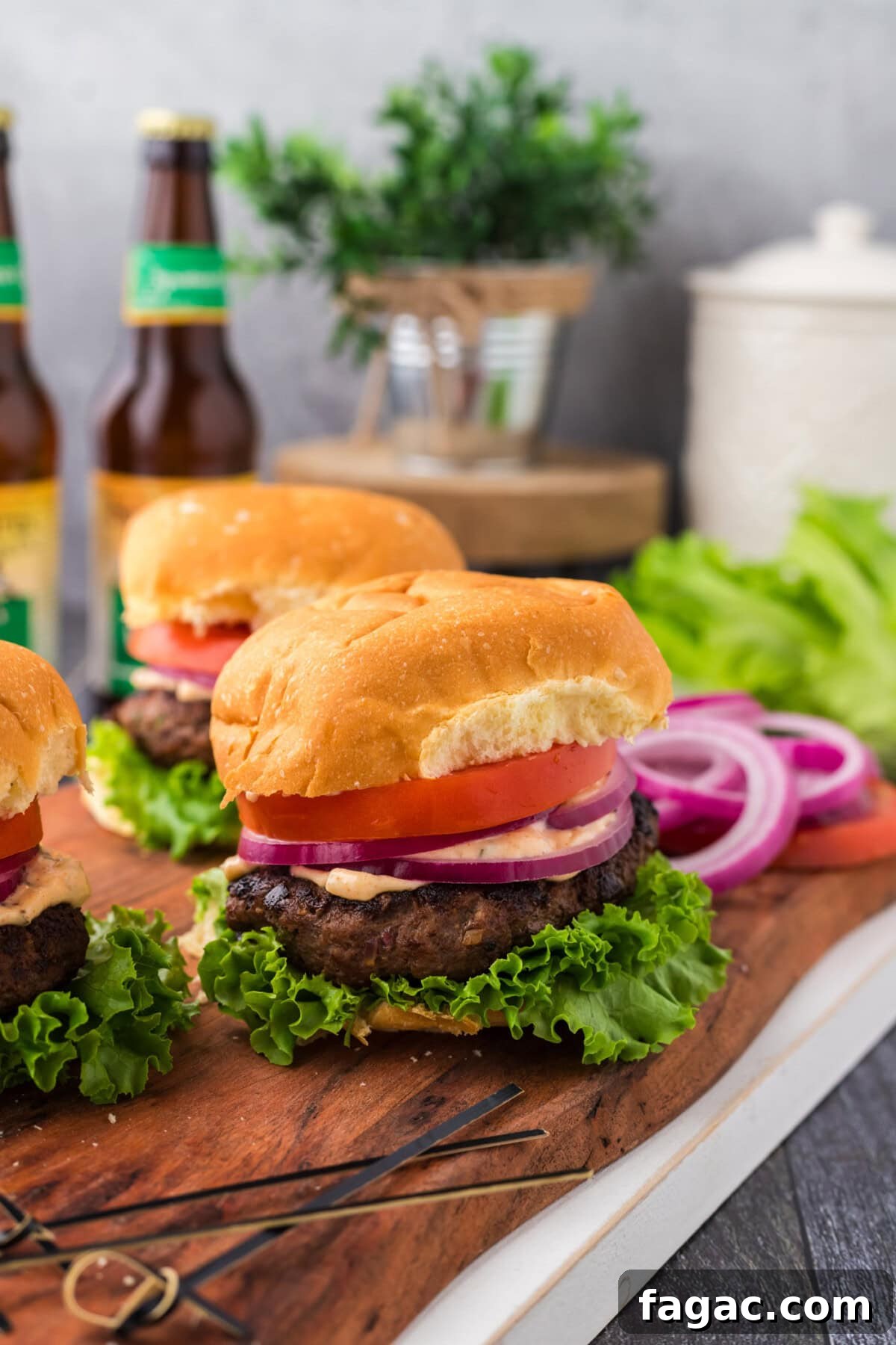 Buffalo Burger Recipe with Blue Cheese and Crispy Onions 2 Buffalo Burger on a wooden board with more burgers behind it