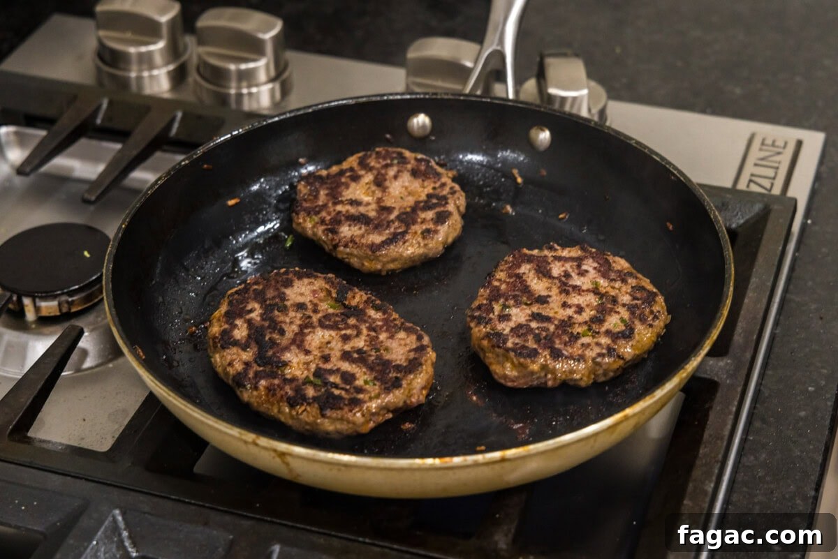 Buffalo Burger Recipe with Blue Cheese and Crispy Onions 11 cooked buffalo burgers in a skillet