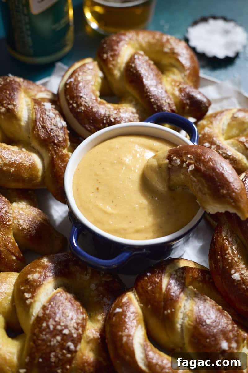 Creamy Beer Cheese Dip for Soft Pretzels 2 Beer Cheese in a small bowl on a platter with soft pretzels.