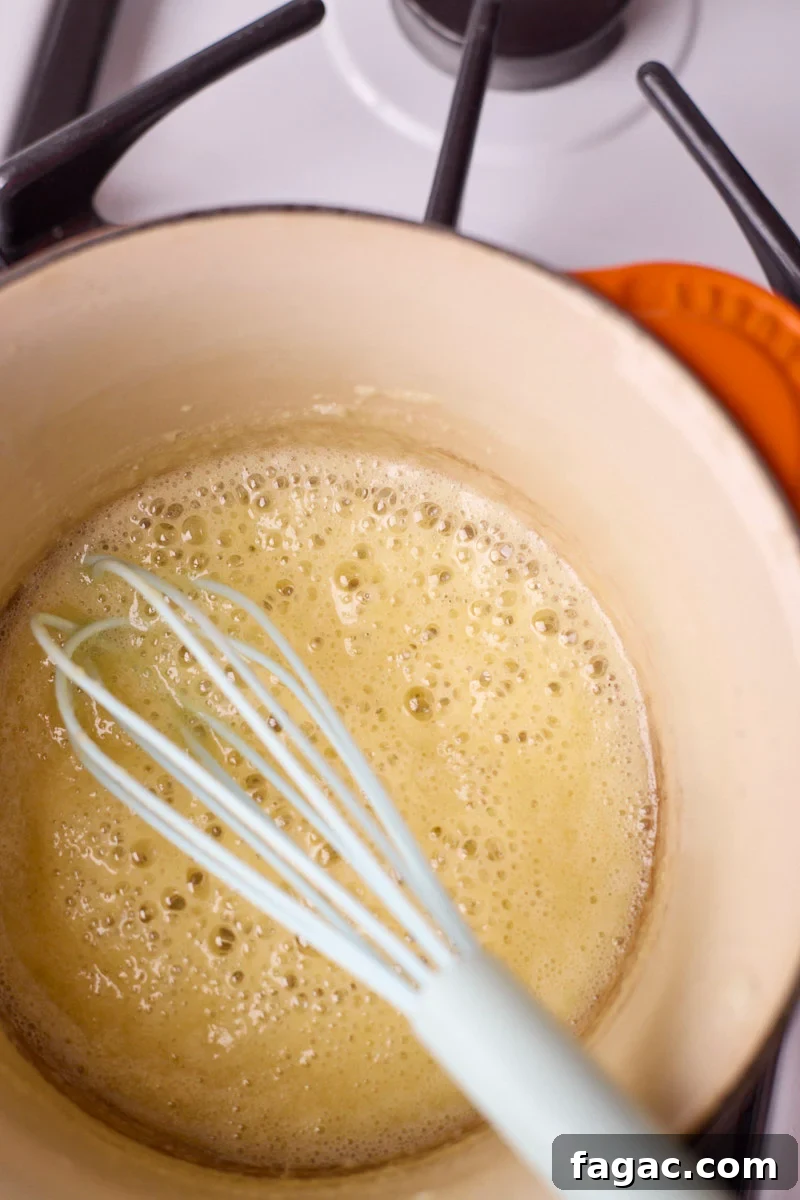 Creamy Beer Cheese Dip for Soft Pretzels 5 Roux with bubbles in a small saucepan.