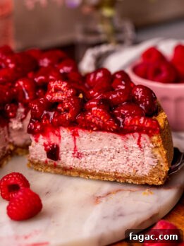 Decadent Raspberry Cheesecake Recipe 10 Taking a slice out of the raspberry cheesecake.