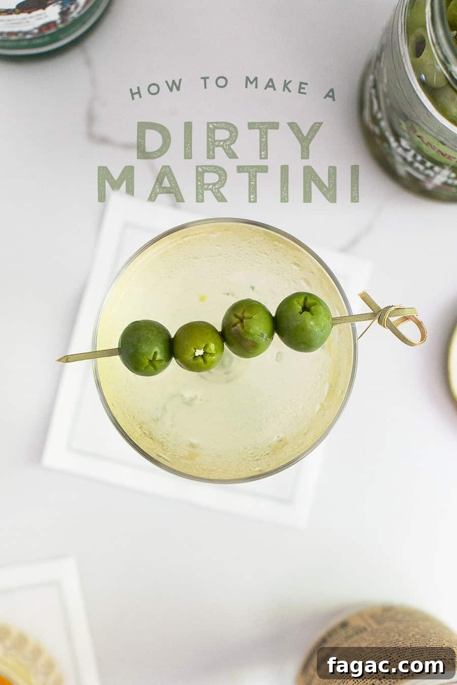 Dirty Martini Recipe: Tips for the Classic Cocktail 2 Dirty martini in a coupe with olives and a pick.