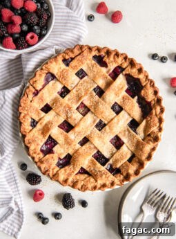Summer Mixed Berry Galette with Flaky Crust 11 triple berry pie on tabletop with a bowl of fresh berries.