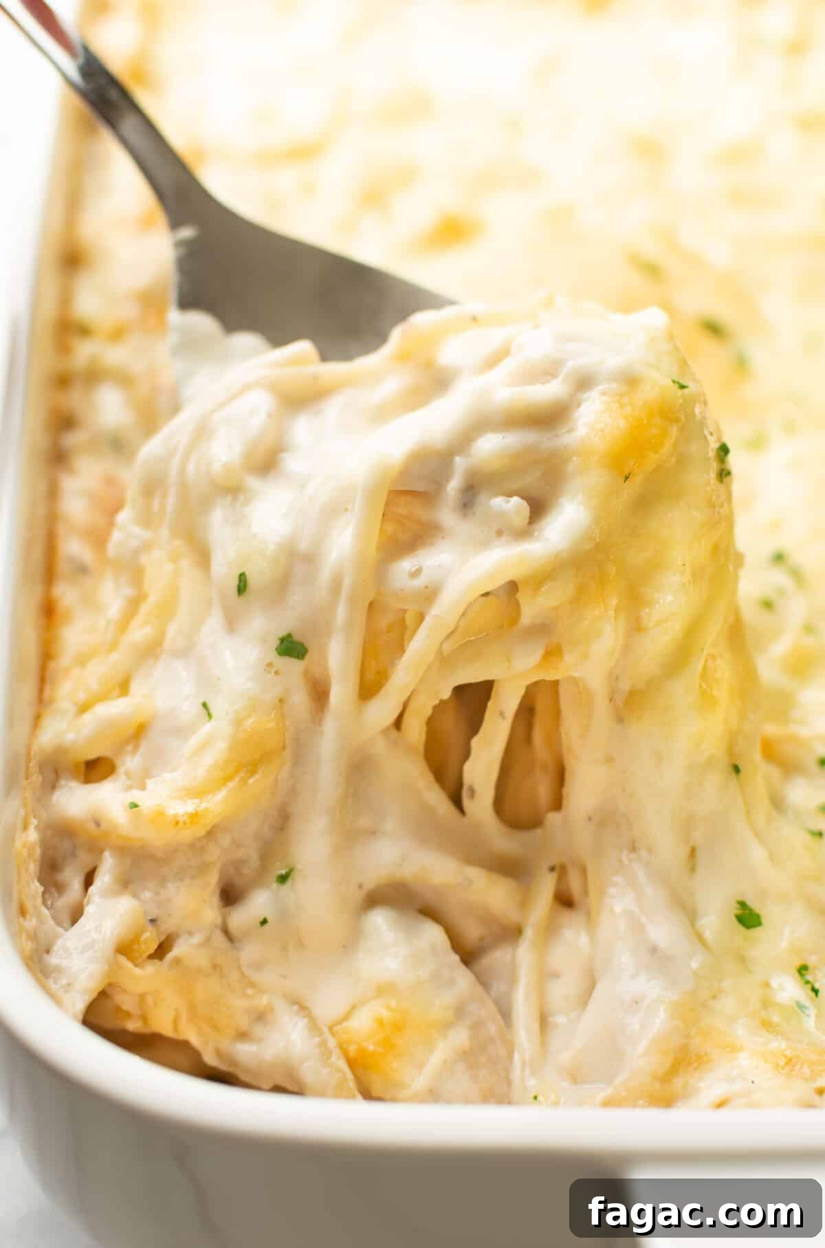 Creamy Turkey Tetrazzini with Mushrooms and Parmesan 2 closeup of a baking dish with turkey tetrazzini and a serving spoon